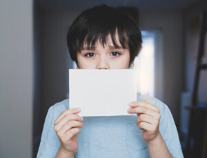 Portrait,of,sad,kid,holding,empty,white,paper,,lonely,child 